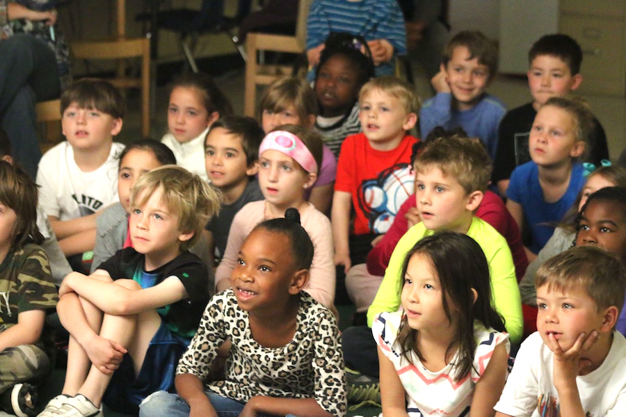 Young students watching a shadow puppet performance
