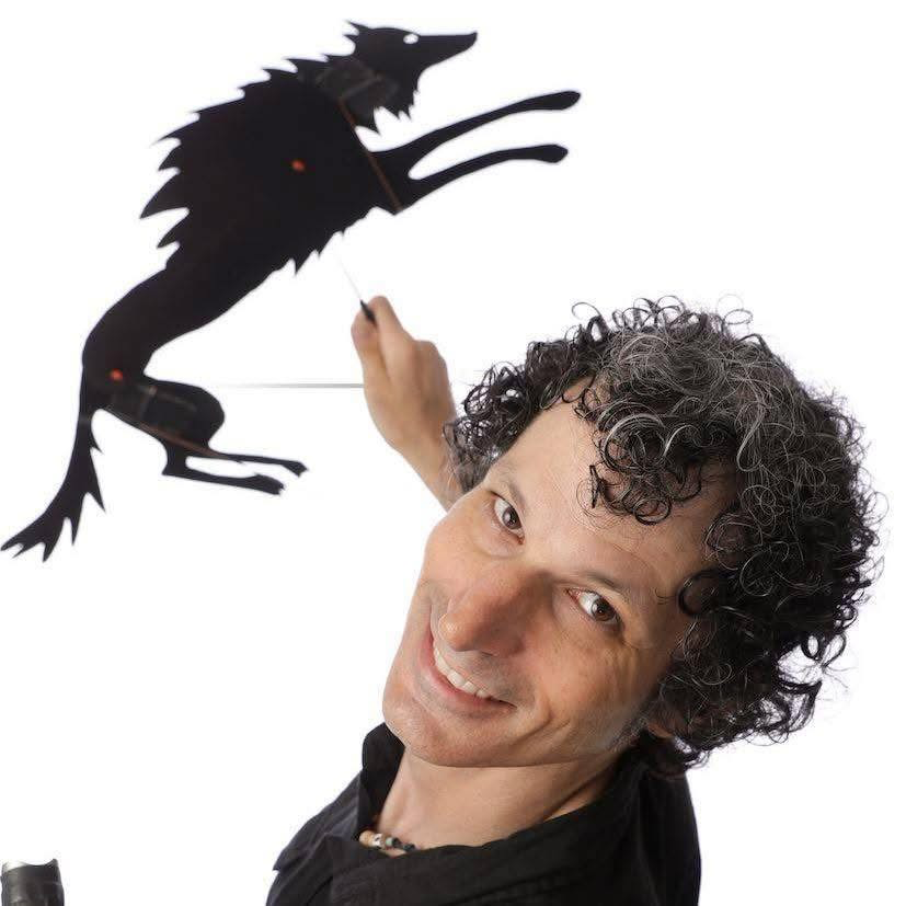 Damon Young performing with a shadow puppet wolf